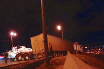 Тяжелая техника пытается вытянуть длинномер на проезжую часть