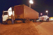 Тяжелая техника пытается вытянуть длинномер на проезжую часть