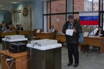Житель Нижнего Новгорода изучает бюллетень в КОИБ (Комплекс обработки избирательных бюллетеней) на одном из избирательных участков в Нижегородском  районе города в день выборов депутатов Государственной Думы РФ шестого созыва