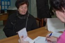 Жительница Нижнего Новгорода получает бюллетень на одном из избирательных участков в Нижегородском  районе города в день выборов депутатов Государственной Думы РФ шестого созыва