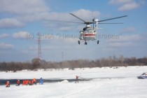 Спасатели закрепляют трос от вертолета к воздушному судну в воде