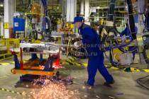 Рабочий сварочного цеха выполняет работы по ручной сварке кузова автомобилей Chevrolet Aveo