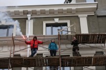 Молодые люди, которые и разместили баннер, жгут файер на уровне четвертого этажа