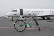 Велосипед сотрудника наземной службы аэропорта, припаркованный около воздушного судна