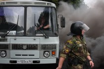 Неизвестный бросил дымовую шашку под автобус с задержанными и полицией