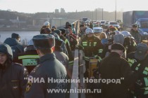 Пожарные спускают в реку с моста установку для забора воды, предназначенной для тушения пожара