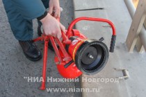 Пожарные спускают в реку с моста установку для забора воды, предназначенной для тушения пожара